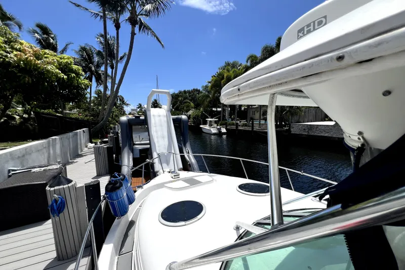 Slide: The Image of 2004 Century 3200 Walk-Around boat docked by a canal with palm trees. - 37