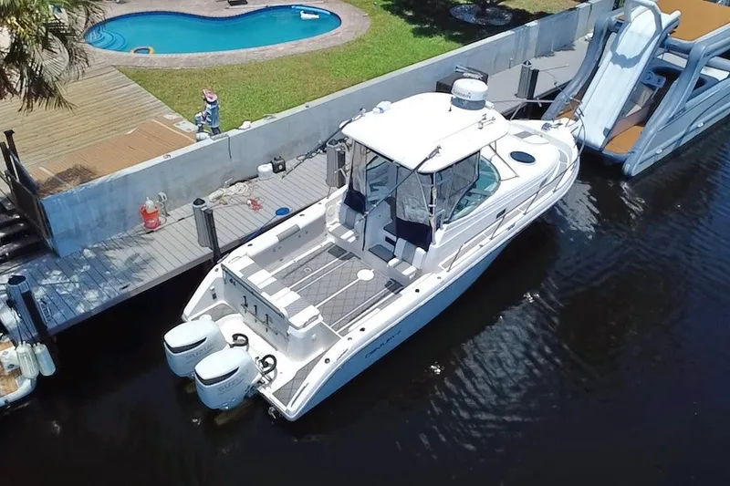 Slide: The Image of 2004 Century 3200 Walk-Around boat docked near a pool and deck. - 20