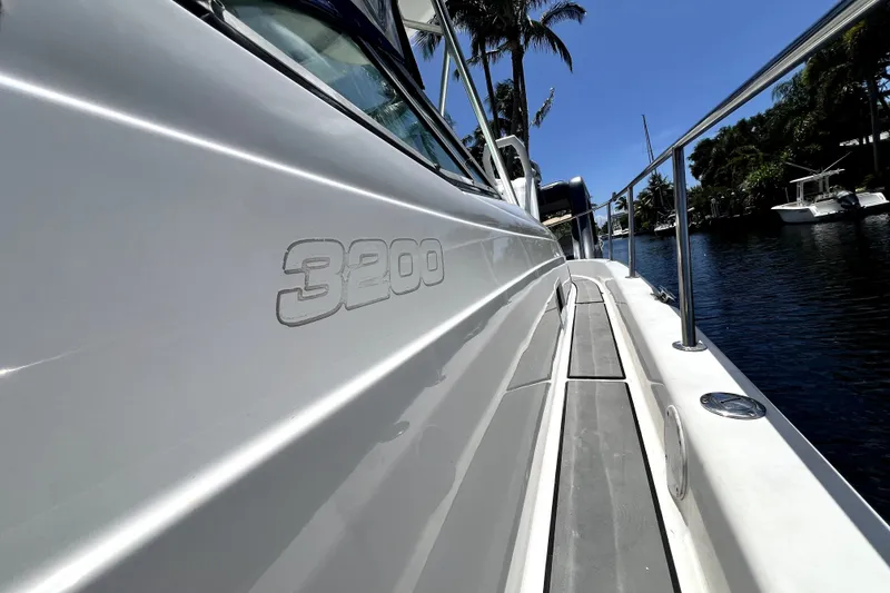 Slide: The Image of 2004 Century 3200 Walk-Around boat docked by a scenic waterfront. - 115