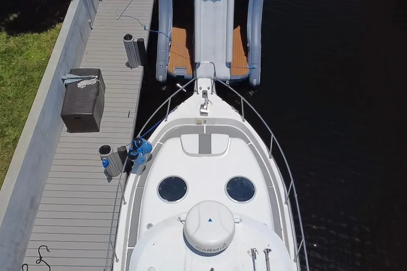 Slide: The Image of Overhead view of a 2004 Century 3200 Walk-Around boat docked beside a wooden deck. - 16