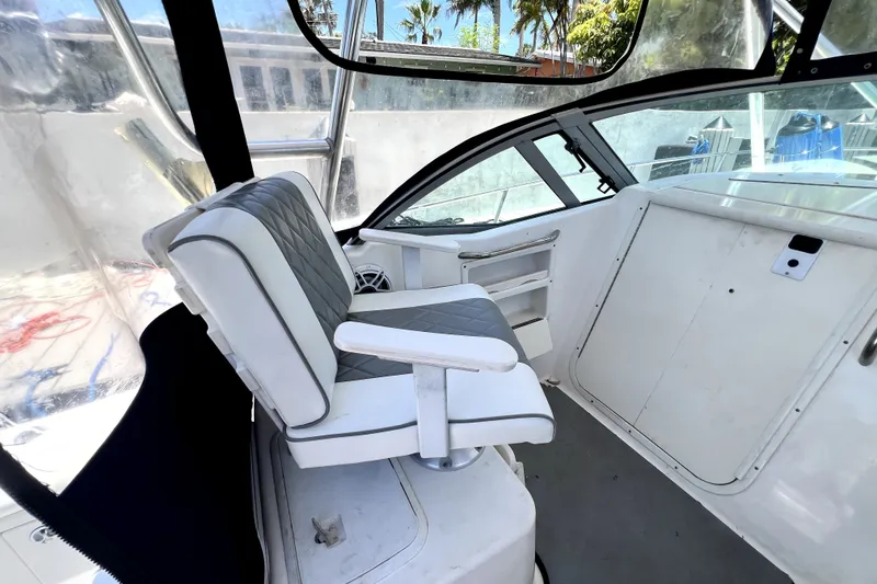 Slide: The Image of 2004 Century 3200 Walk-Around boat interior with cushioned seating and helm area. - 91