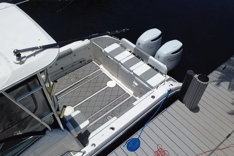 Slide: The Image of 2004 Century 3200 Walk-Around boat docked with dual Suzuki outboard motors. - 11