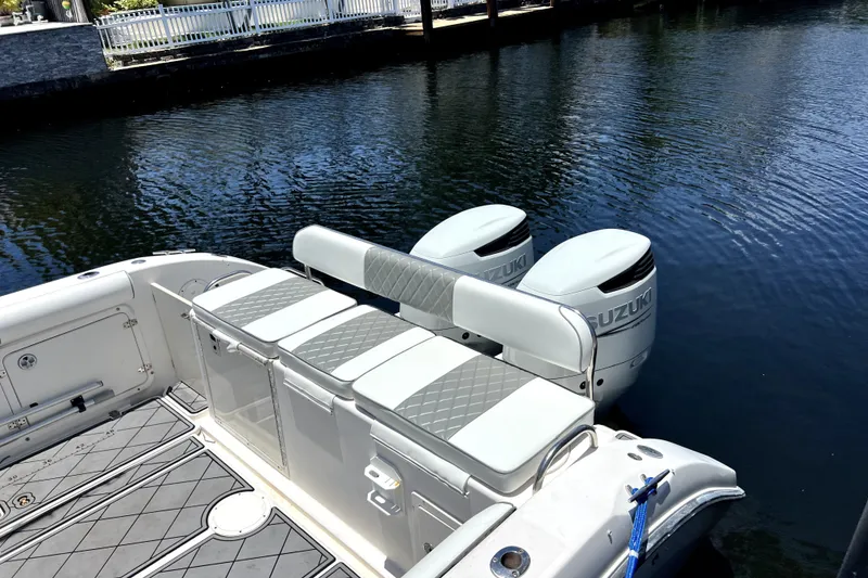 Slide: The Image of 2004 Century 3200 Walk-Around boat with Suzuki engines, docked on calm water. - 24