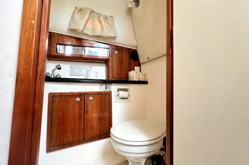 Slide: The Image of 2004 Century 3200 Walk-Around boat bathroom with wooden cabinets and compact design. - 106