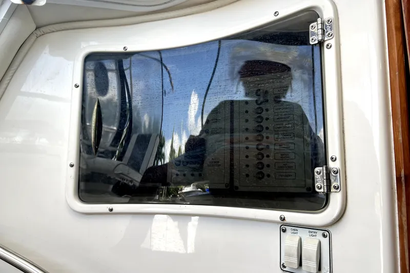 Slide: The Image of Control panel on a 2004 Century 3200 Walk-Around boat, featuring switches and reflective glass. - 63
