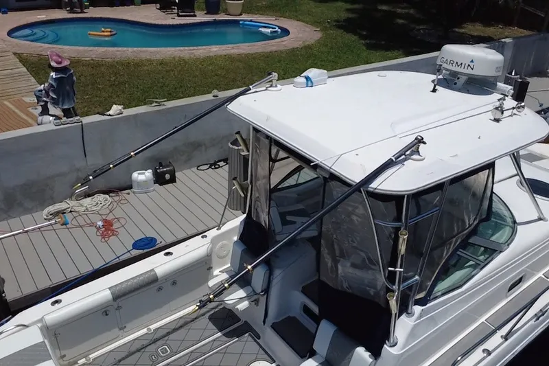 Slide: The Image of 2004 Century 3200 Walk-Around boat docked near a swimming pool. - 14