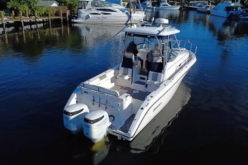 Slide: The Image of 2004 Century 3200 Walk-Around boat with dual engines on a calm marina. - 6