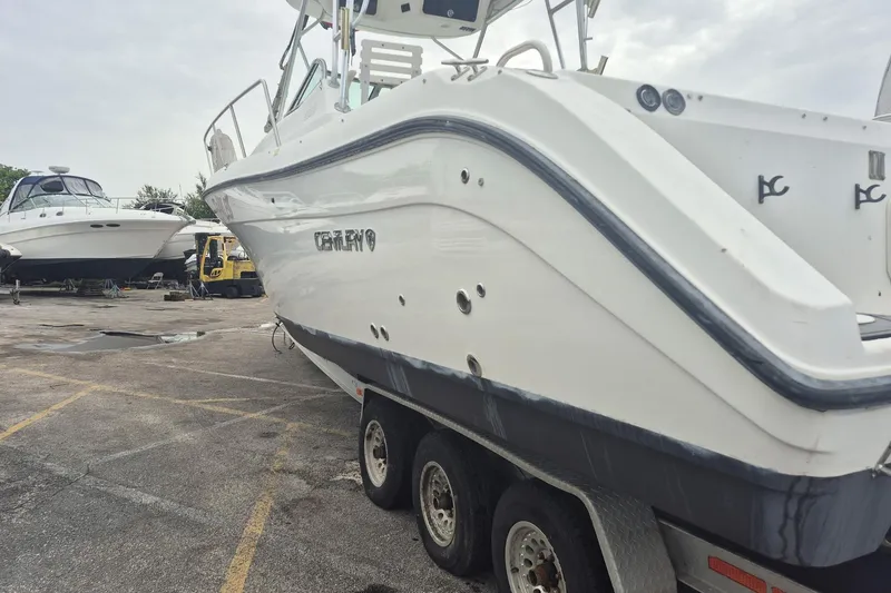 Slide: The Image of 2004 Century 3200 Walk-Around boat on trailer in a marina setting. - 7