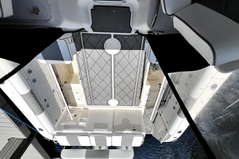Slide: The Image of 2004 Century 3200 Walk-Around boat interior with cushioned seating and storage compartments. - 76