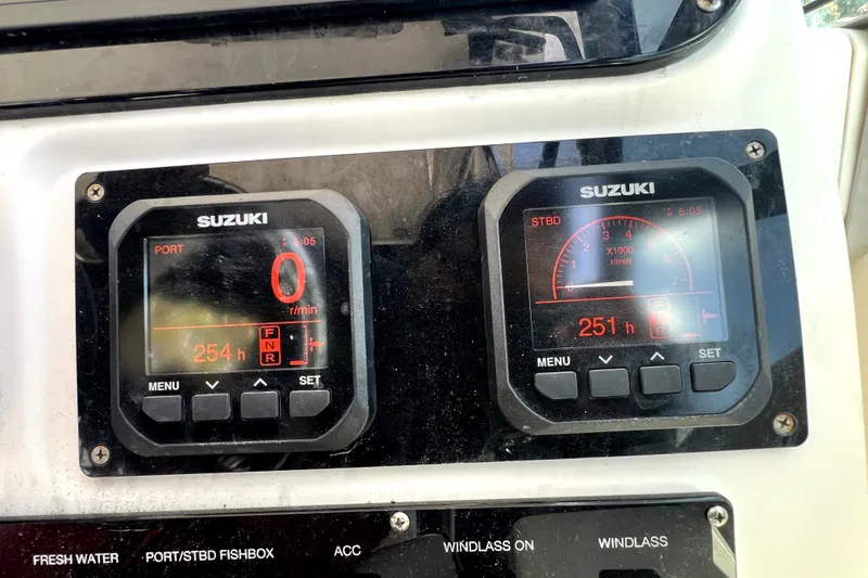 Slide: The Image of Suzuki engine gauges on a 2004 Century 3200 Walk-Around boat dashboard. - 92
