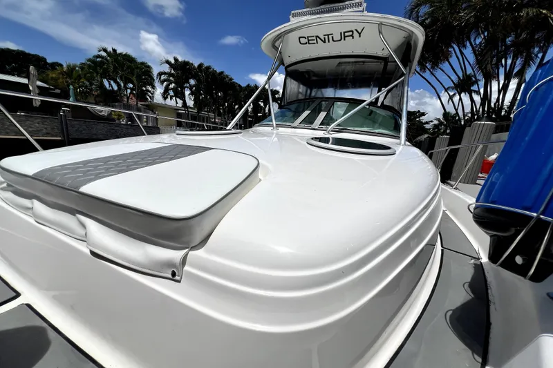 Slide: The Image of 2004 Century 3200 Walk-Around boat with sleek design, docked under a clear blue sky. - 39