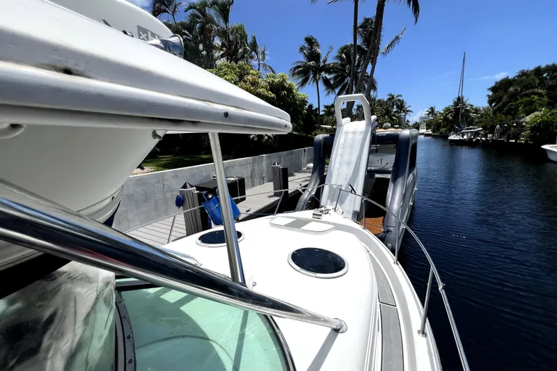 Slide: The Image of 2004 Century 3200 Walk-Around boat docked by a canal with palm trees. - 46