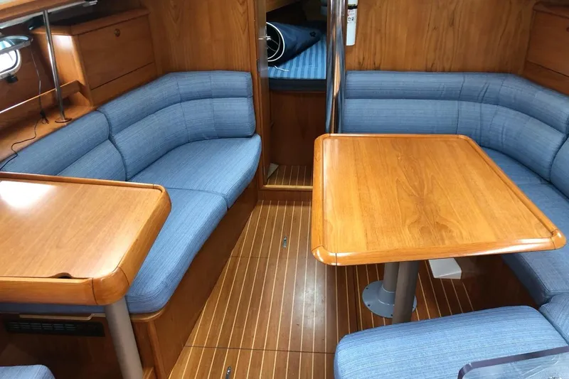 Slide: The Image of Interior of 2000 Jeanneau Sun Odyssey 36.2 yacht with wooden table and blue seating. - 27