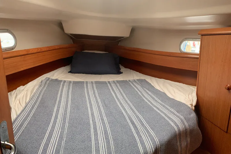 Slide: The Image of Cozy cabin interior of 2000 Jeanneau Sun Odyssey 37 sailboat with striped bedding. - 19