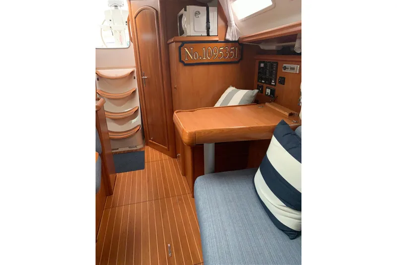 Slide: The Image of Interior of 2000 Jeanneau Sun Odyssey 37 sailboat with wood finish and striped cushions. - 31