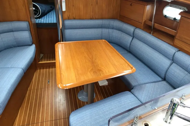 Slide: The Image of Interior of 2000 Jeanneau Sun Odyssey 36.2 yacht with blue seating and wooden table. - 26