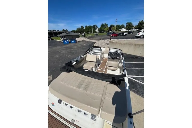 Slide: The Image of 2016 Bayliner VR5 Bowrider I/O with beige seating, parked outdoors under clear skies. - 5
