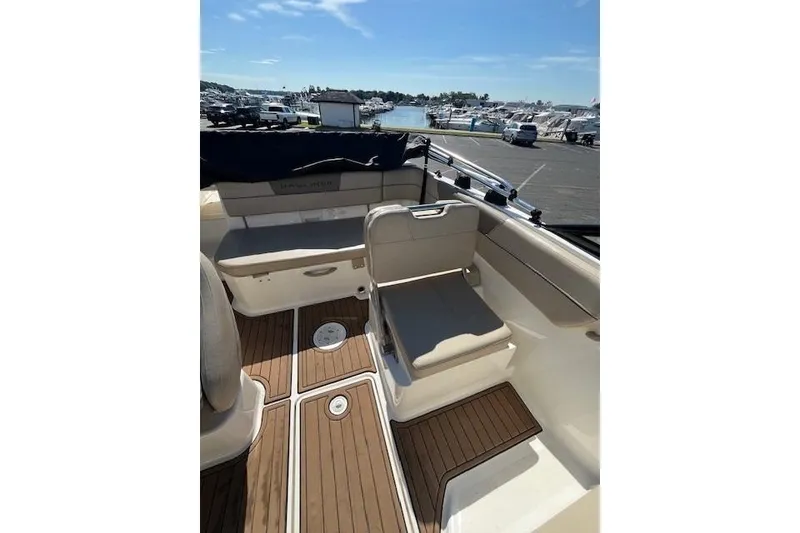 Slide: The Image of 2016 Bayliner VR5 Bowrider I/O interior with seating and wood flooring, dockside view. - 7