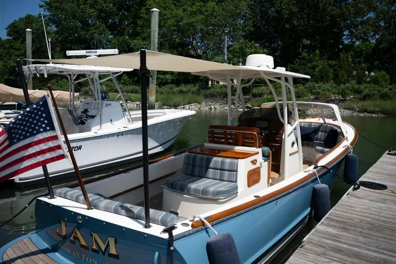 Slide: The Image of 2021 Hinckley Talaria 29C docked, featuring elegant design and American flag. - 6