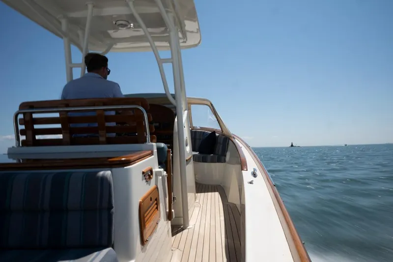 Slide: The Image of 2021 Hinckley Talaria 29C cruising on open water under clear blue skies. - 14