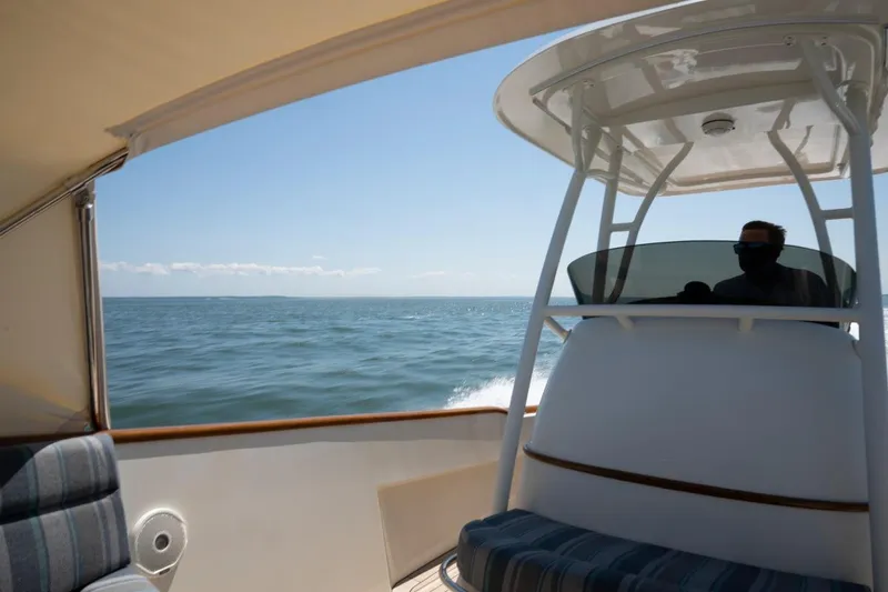 Slide: The Image of 2021 Hinckley Talaria 29C cruising on open water under clear blue skies. - 13