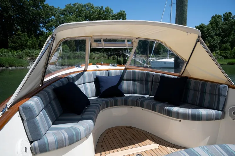 Slide: The Image of Luxurious seating area on a 2021 Hinckley Talaria 29C boat, featuring striped cushions. - 16