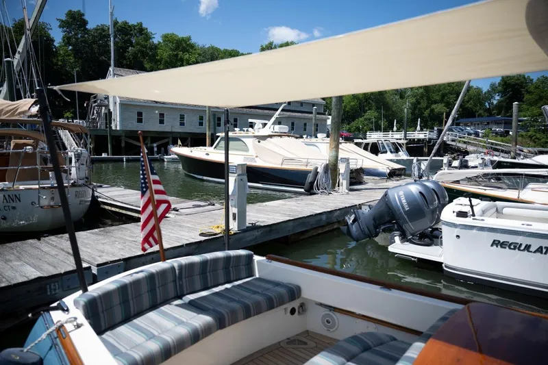 Slide: The Image of Hinckley Talaria 29C 2021 docked at a marina with boats and American flag. - 17
