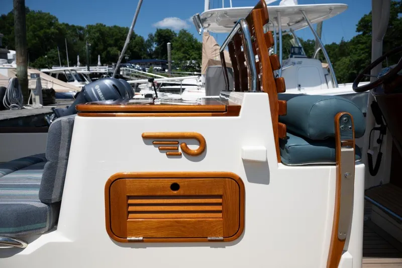 Slide: The Image of 2021 Hinckley Talaria 29C boat detail with wooden accents at marina. - 18