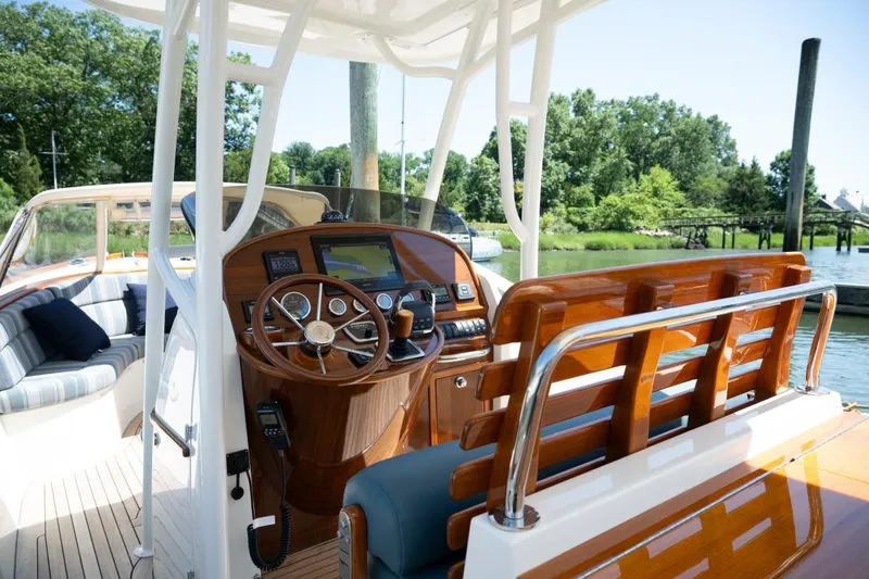 Slide: The Image of 2021 Hinckley Talaria 29C boat interior with polished wood and modern navigation equipment. - 8