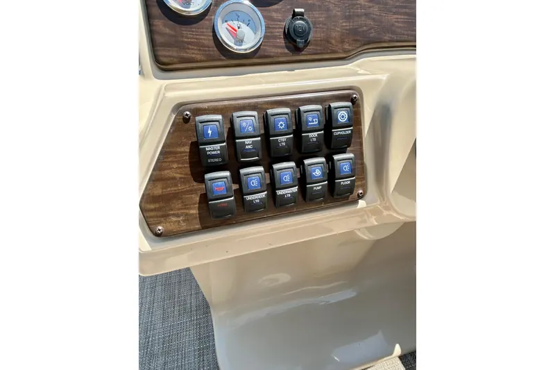 Slide: The Image of Control panel of a 2017 Starcraft CX 23 RE boat with labeled switches. - 21