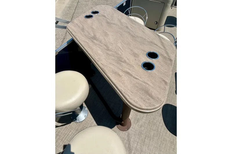 Slide: The Image of 2017 Starcraft CX 23 RE boat interior with table and cup holders. - 30