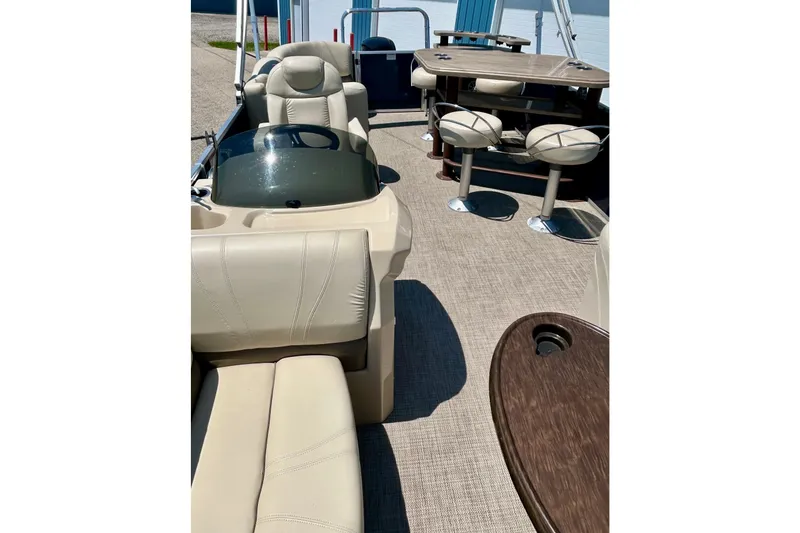Slide: The Image of 2017 Starcraft CX 23 RE pontoon boat interior with beige seating and dining area. - 27