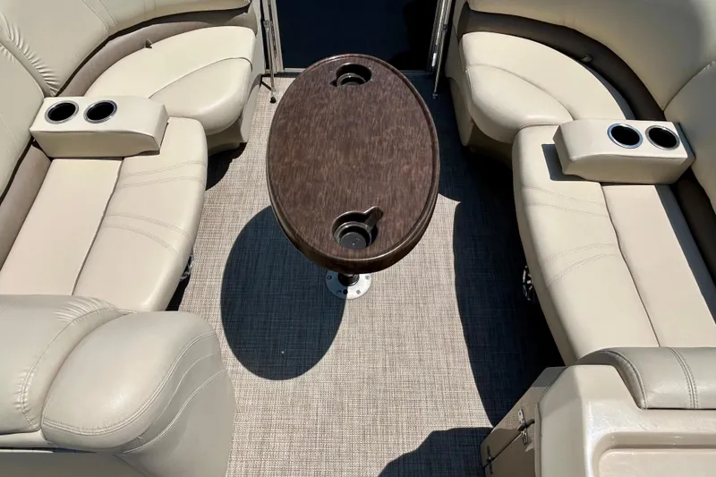 Slide: The Image of 2017 Starcraft CX 23 RE boat interior with beige seating and central table. - 26