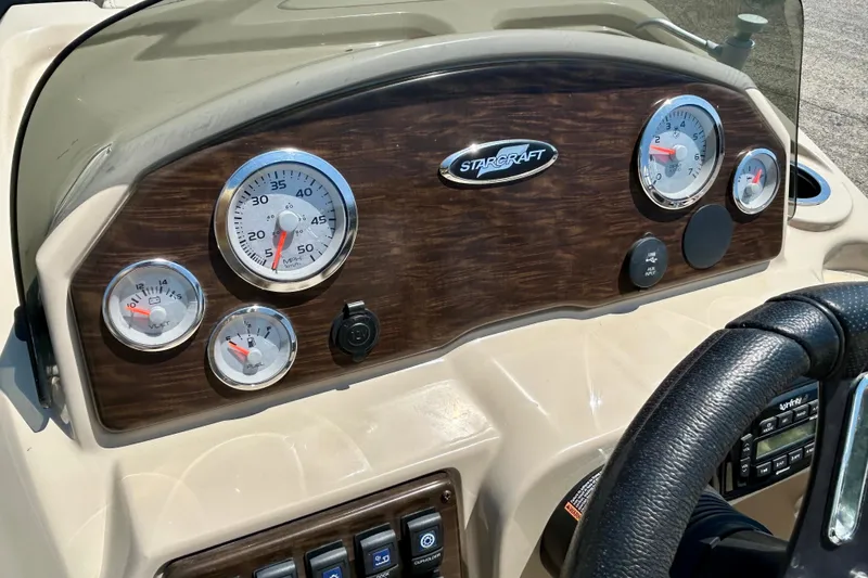 Slide: The Image of Dashboard of 2017 Starcraft CX 23 RE boat with gauges and steering wheel. - 24