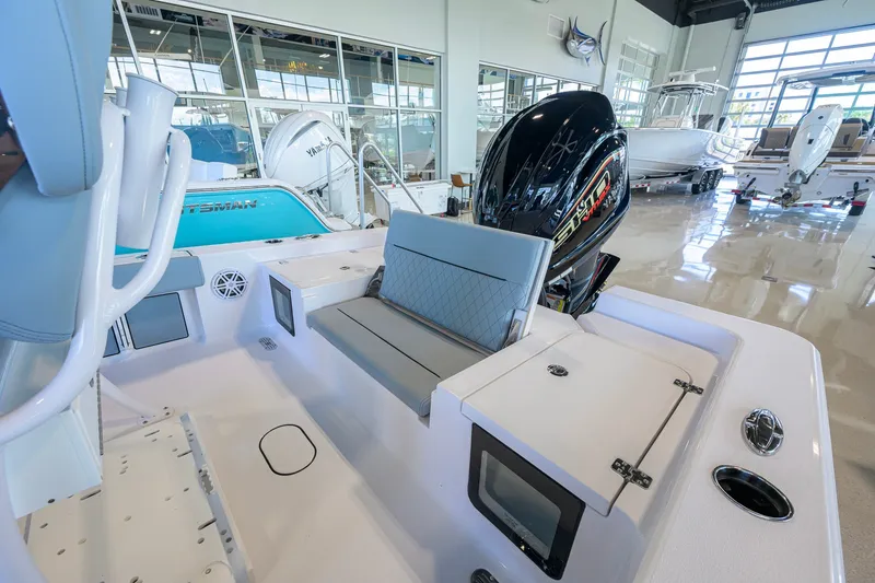 Slide: The Image of 2027 Sportsman Masters 227 Bay Boat interior with seating and motor in showroom. - 37