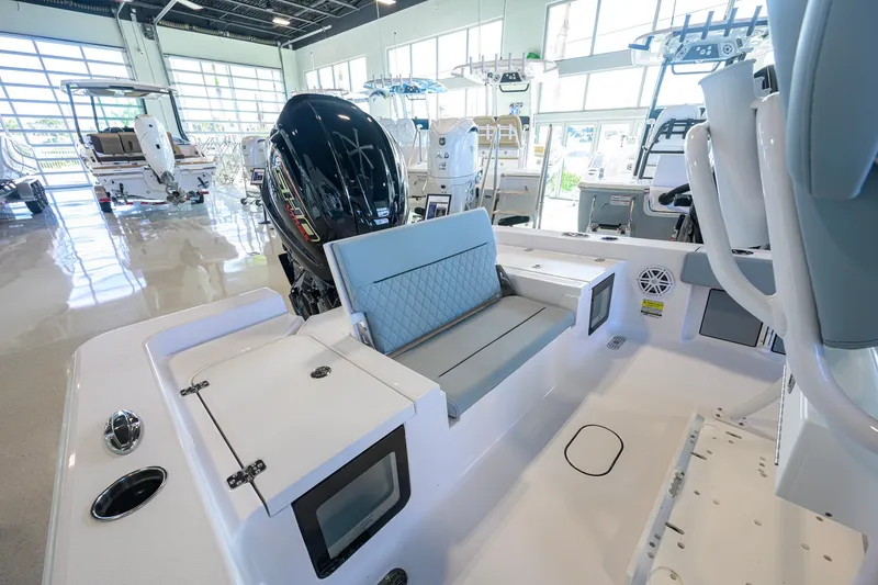 Slide: The Image of 2027 Sportsman Masters 227 Bay Boat interior with seating and motor in showroom. - 30