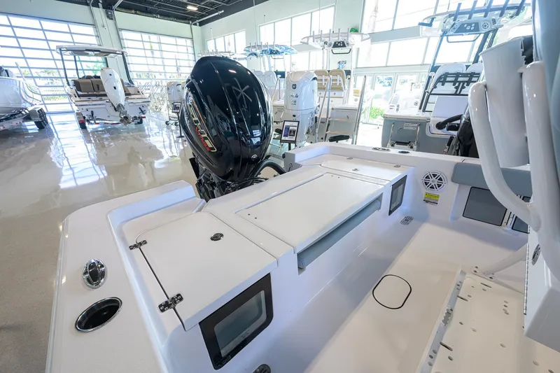 Slide: The Image of 2027 Sportsman Masters 227 Bay Boat interior with engine, showcased in a bright showroom. - 29