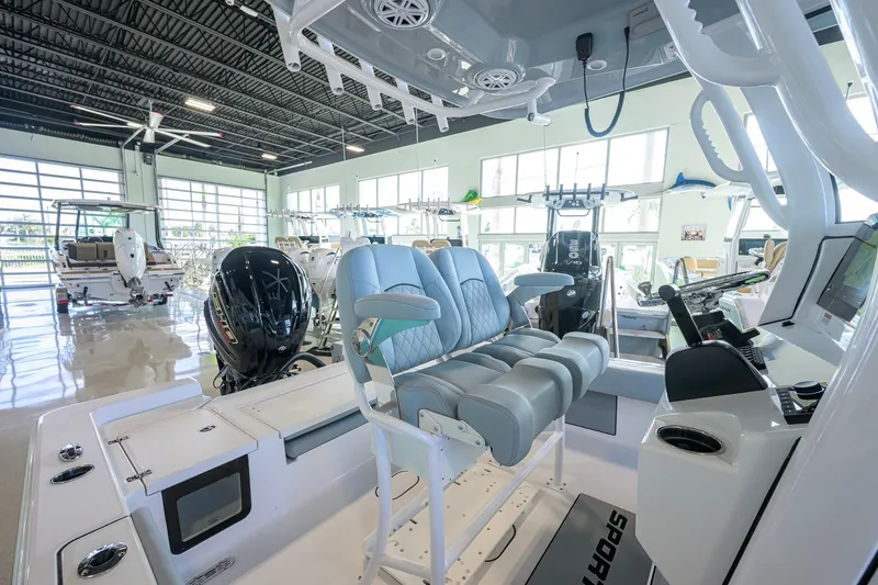 Slide: The Image of 2027 Sportsman Masters 227 Bay Boat interior with modern seating and controls in showroom. - 27