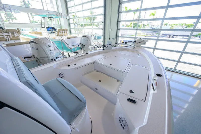 Slide: The Image of 2027 Sportsman Masters 227 Bay Boat interior with seating and storage in a showroom. - 25