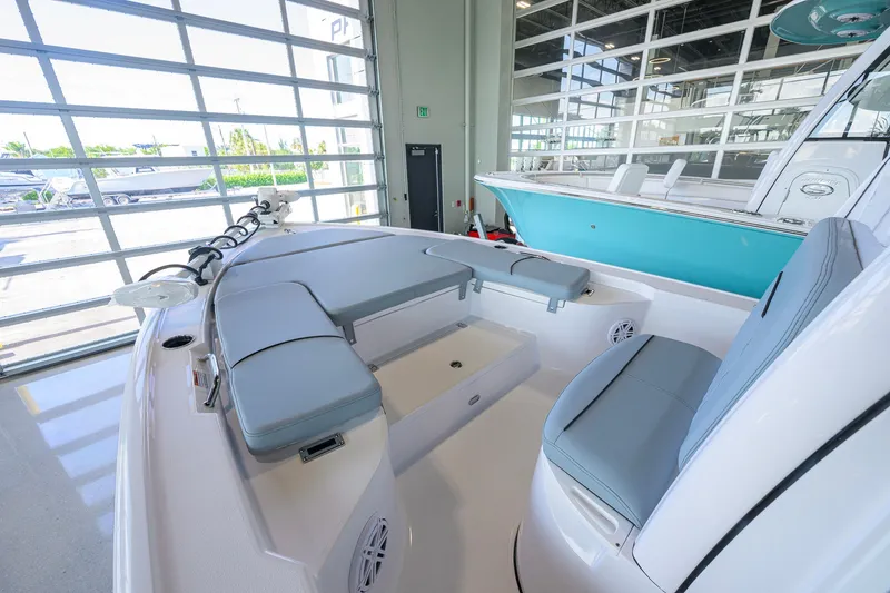 Slide: The Image of 2027 Sportsman Masters 227 Bay Boat interior with cushioned seating in showroom. - 11
