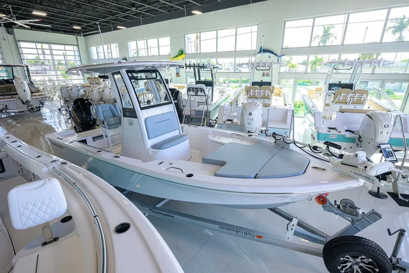 Slide: The Image of 2027 Sportsman Masters 227 Bay Boat displayed in a showroom with other boats. - 1