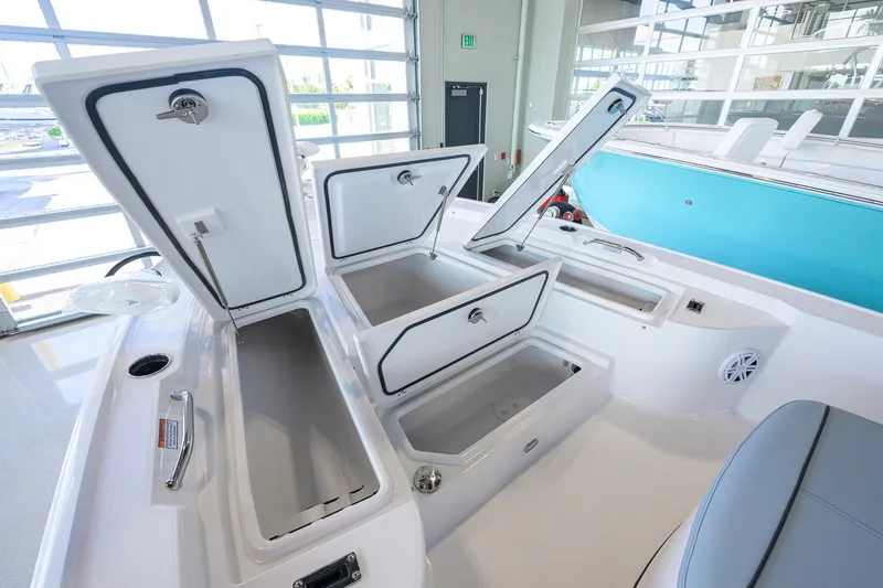 Slide: The Image of 2027 Sportsman Masters 227 Bay Boat interior with open storage compartments in a showroom. - 17