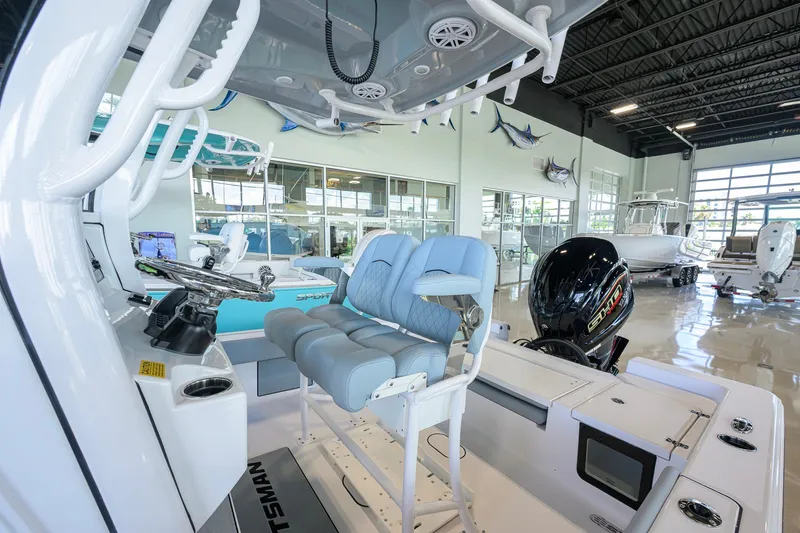 Slide: The Image of 2027 Sportsman Masters 227 Bay Boat interior with seating and controls in showroom. - 10