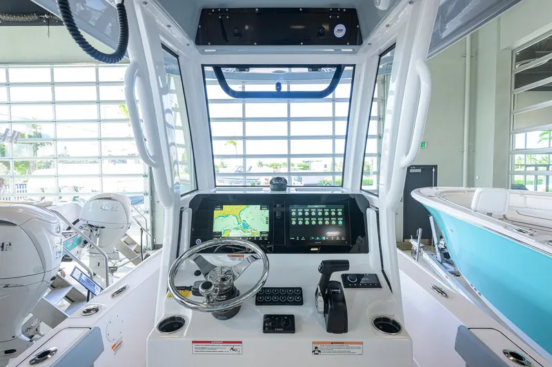 Slide: The Image of 2027 Sportsman Masters 227 Bay Boat dashboard with navigation display and steering wheel. - 8