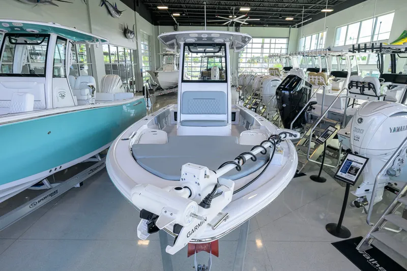 Slide: The Image of 2027 Sportsman Masters 227 Bay Boat displayed in a showroom with other boats. - 2