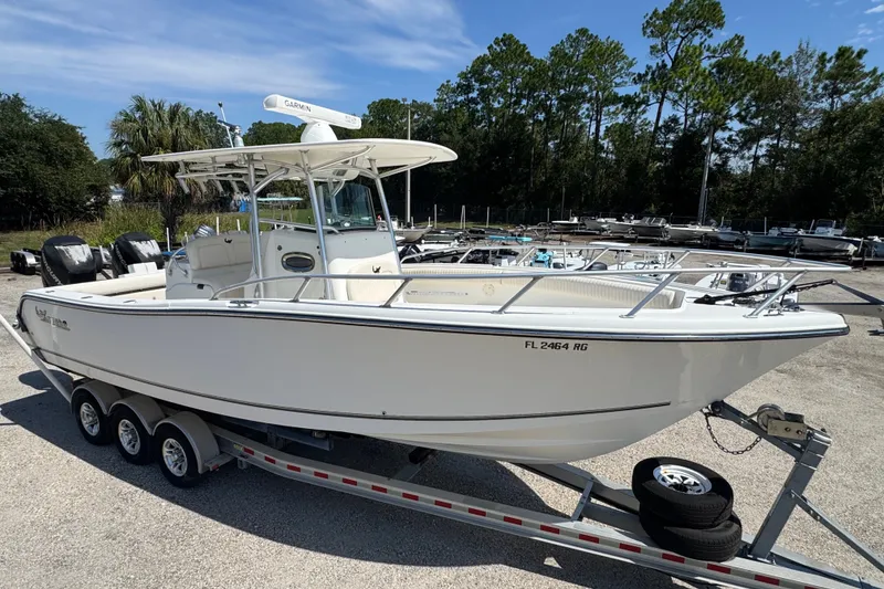 The Image of 2014 Mako 284 Center Console boat on trailer, parked outdoors. - 0