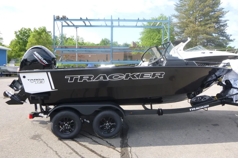 The Image of 2027 Tracker Targa V-18 Combo boat on trailer, black exterior, parked outdoors. - 1