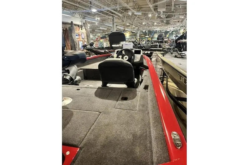 Slide: The Image of 2026 Tracker Pro Crappie 175 boat interior with red trim in showroom. - 4