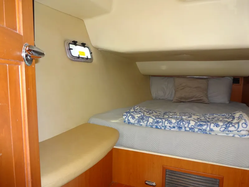 Slide: The Image of A cozy cabin with a double bed, wooden furnishings, and a small side window. - 40