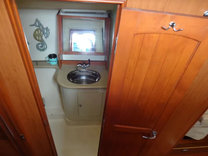 Slide: The Image of The image shows a boat bathroom with a sink, mirror, and wooden doors. - 33